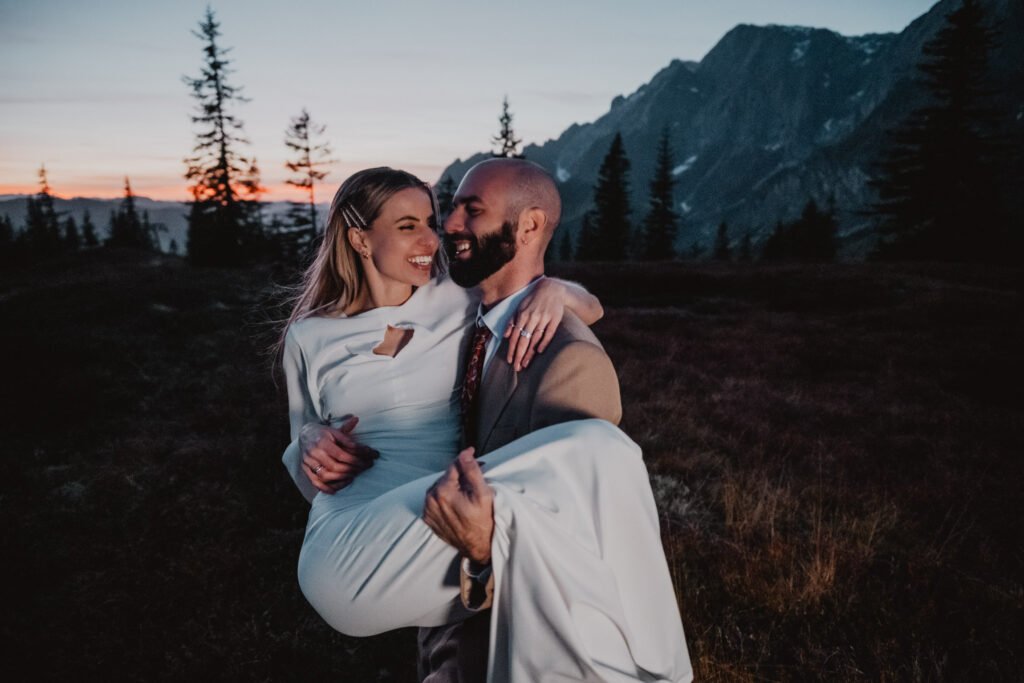 Groom carrying the smiling bride in the mountains.