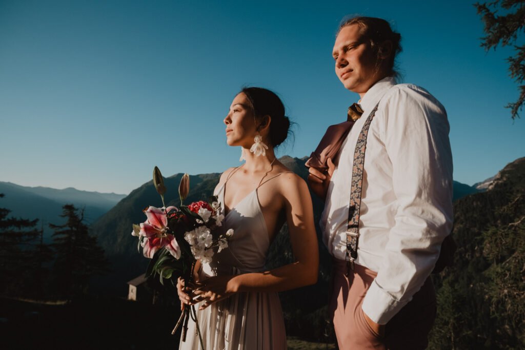 Couple looking into the distance with a bouquet in the evening sunlight.