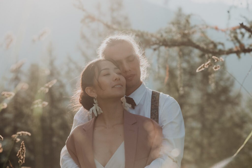 Close portrait of a couple embracing in warm backlight.