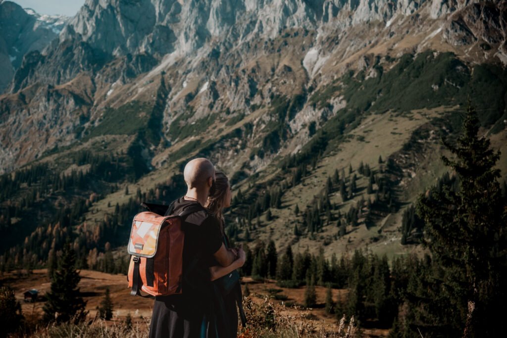 Hiker with a backpack looking towards the mountains.