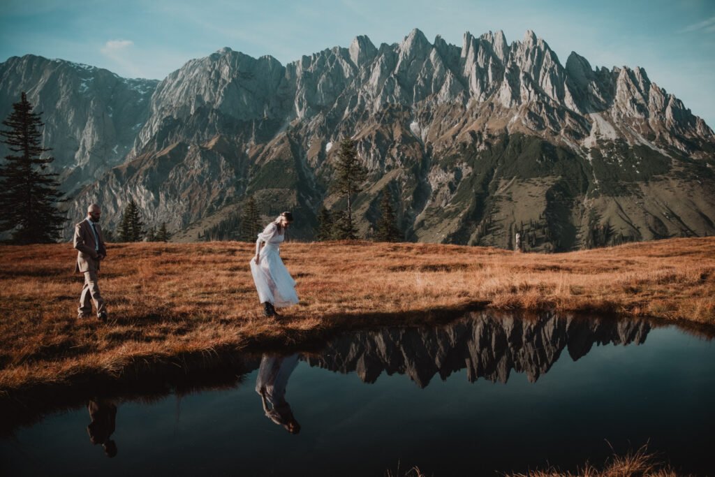 Couple walking around the edge of a mountain pond.