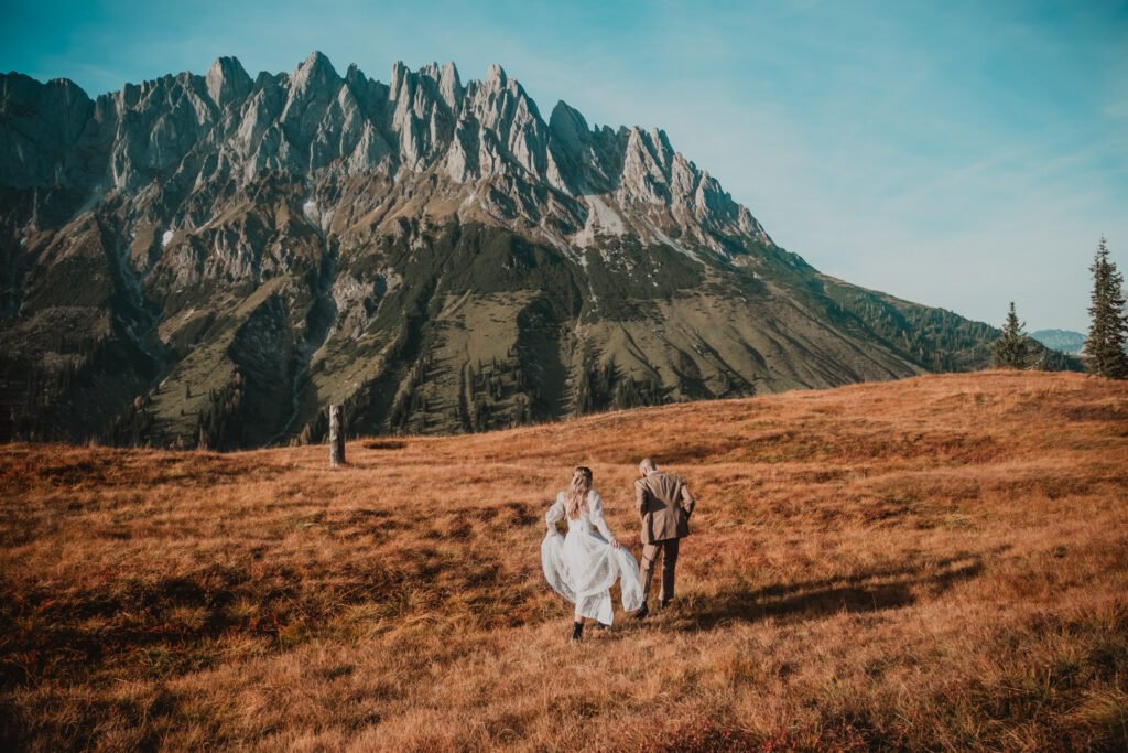 Couple sitting together in a mountain meadow.