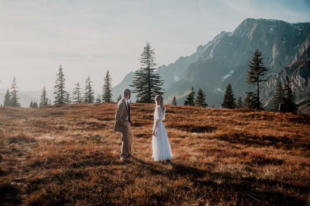 Couple facing each other in a mountain meadow.