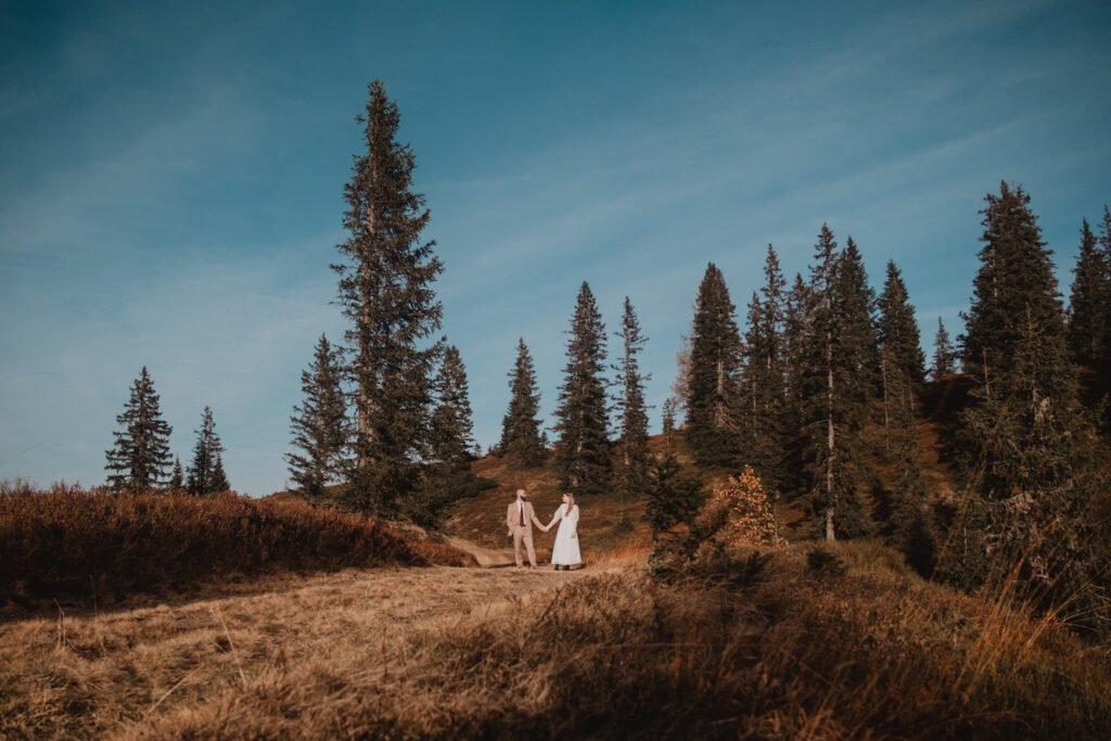 Couple in a mountain meadow surrounded by autumn larches.