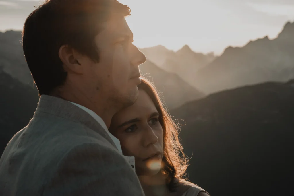 Couple embracing in warm, backlit sunlight.