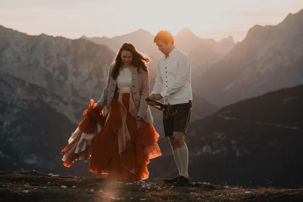 Couple walking with the bride's orange skirt flowing behind her.