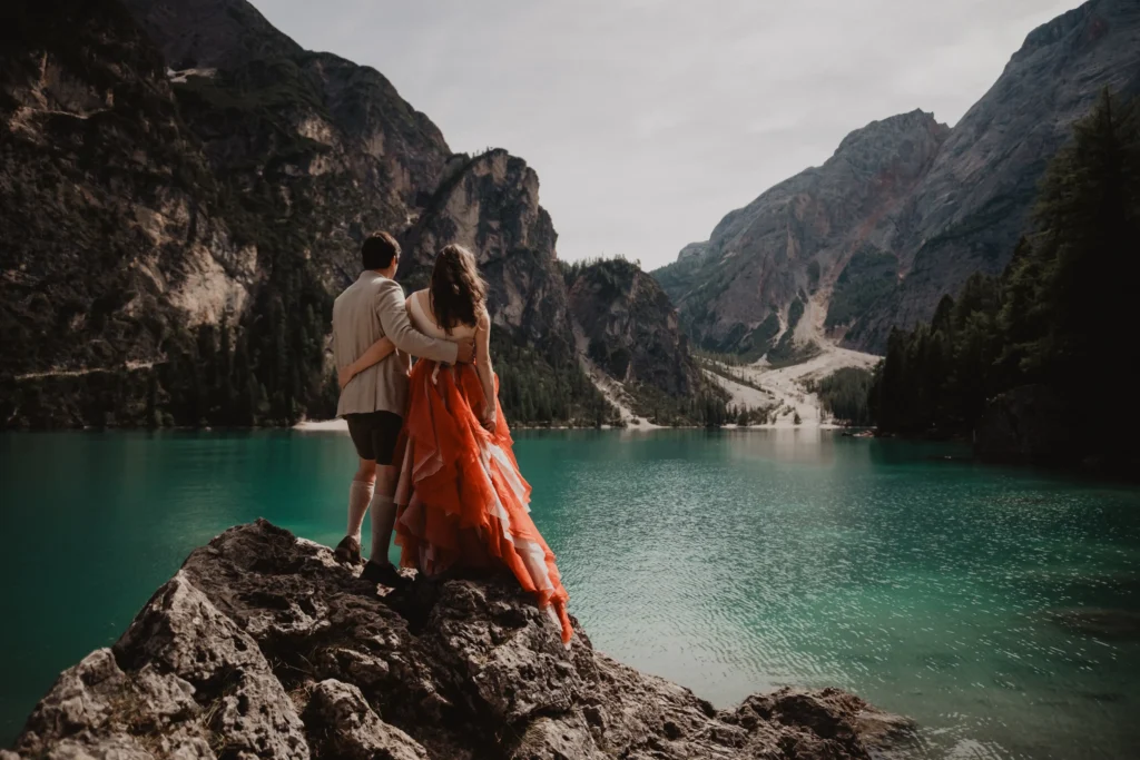 Couple embracing on a rocky lakeshore.