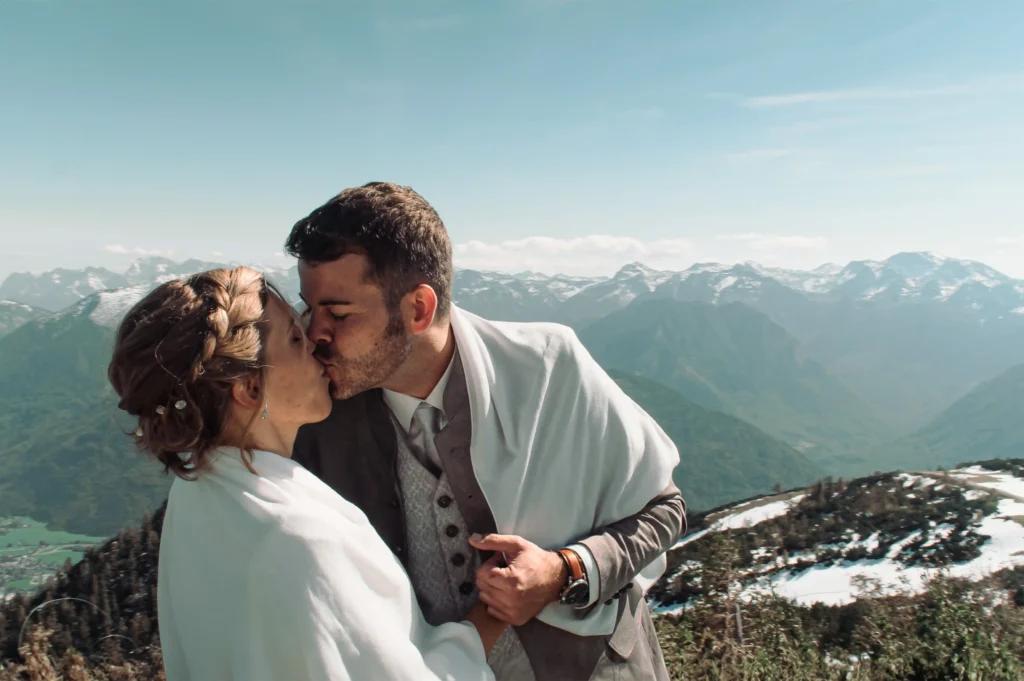 Couple kissing with a wrap around their shoulders.