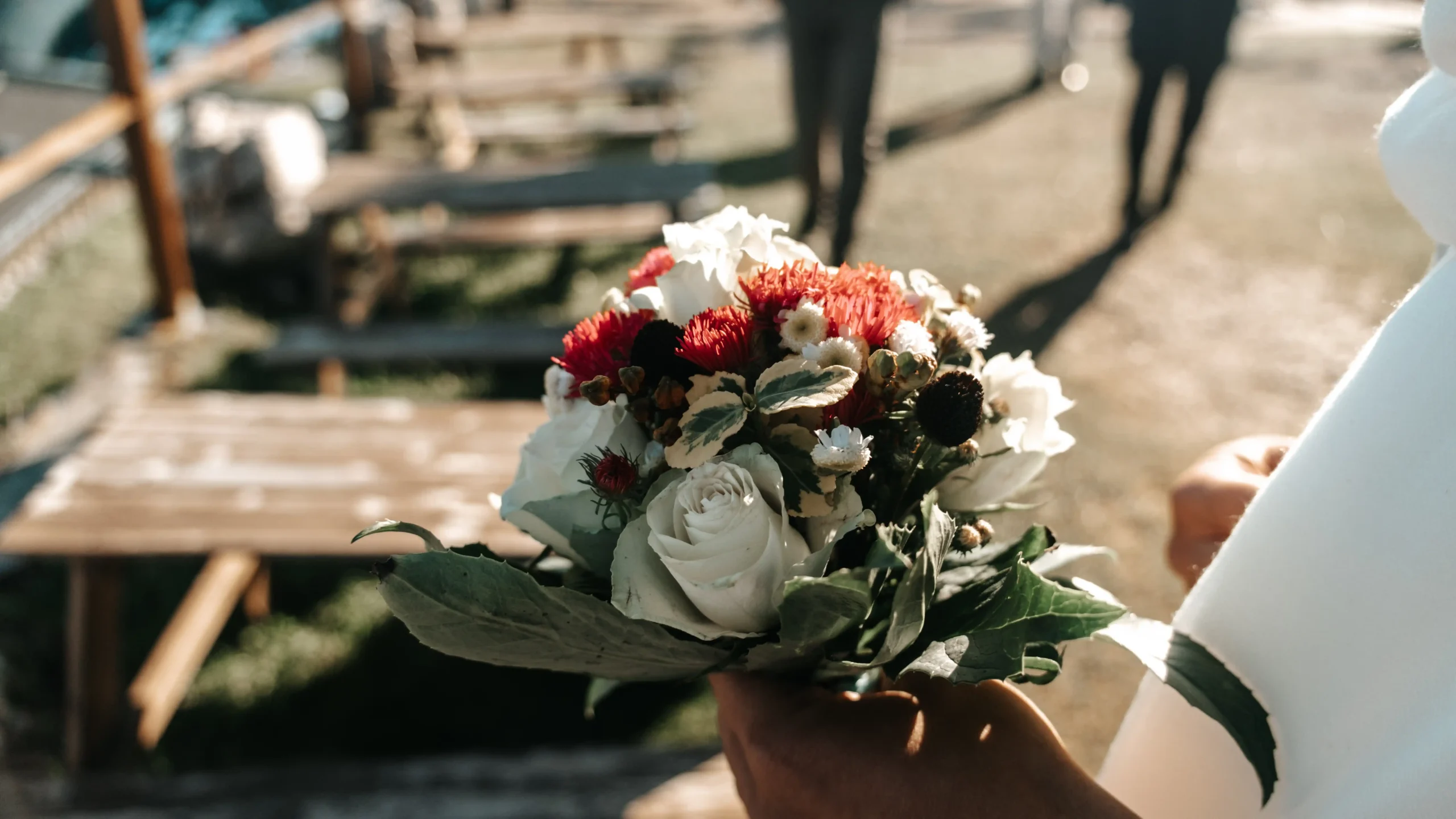 Nahaufnahme eines Brautstraußes mit weißen und korallfarbenen Rosen.