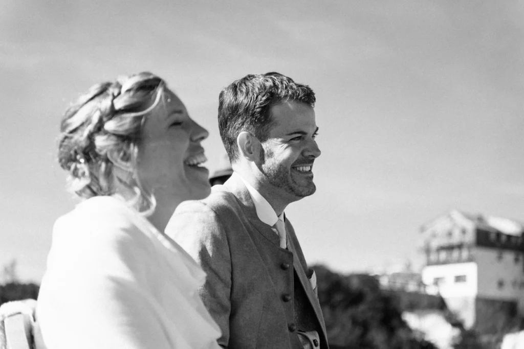 Black-and-white close portrait of a couple laughing together.