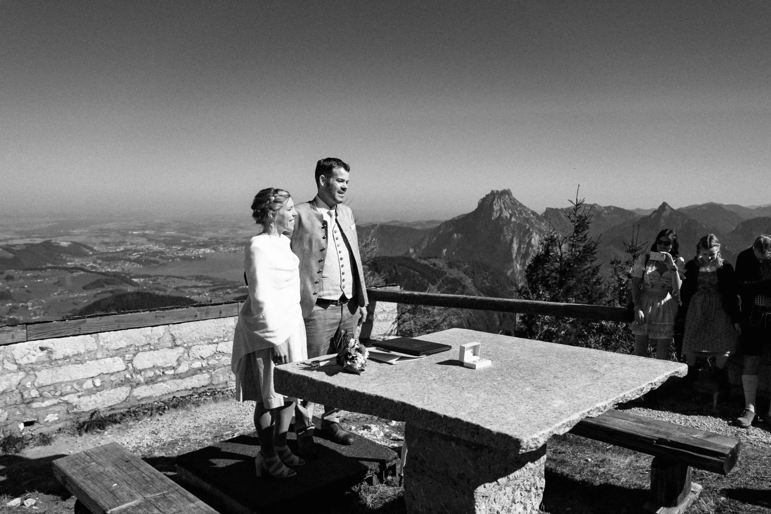 Schwarz-Weiß-Ansicht eines Paares am Zeremonientisch auf einer Bergterrasse.