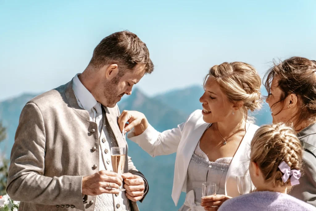 Groom chatting with wedding guests over drinks.