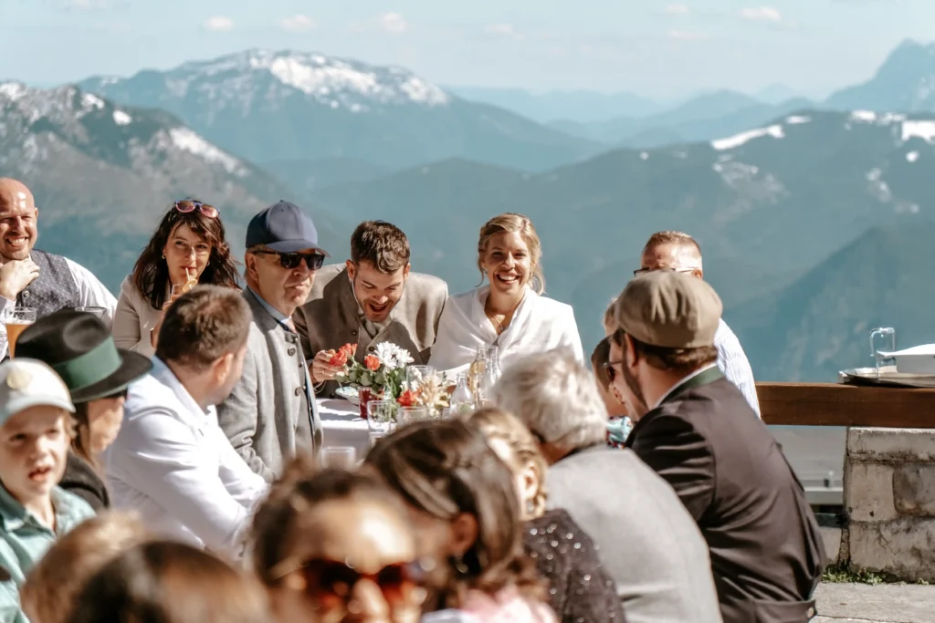 Wedding guests at an outdoor table overlooking the mountains.