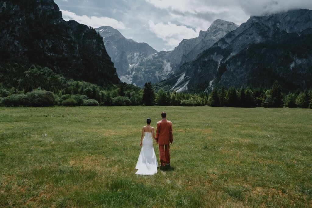 Elias and Wendy looking across a meadow towards the mountains.