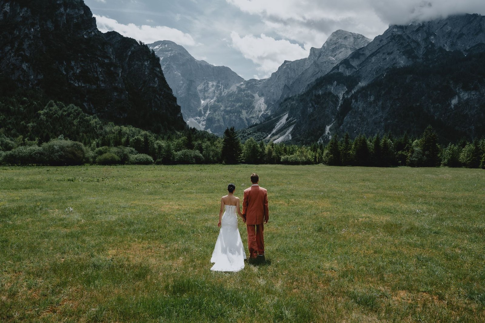 Elias und Wendy blicken über eine Wiese zu den Bergen.