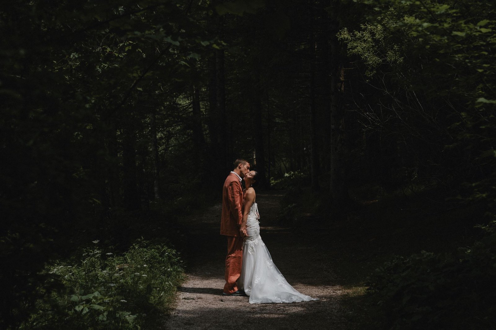 Elias und Wendy in Hochzeitskleidung auf einem Waldweg.