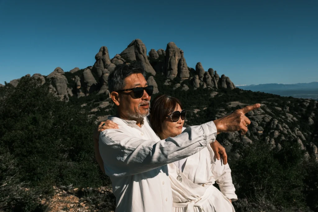 Man pointing into the distance while embracing his partner.