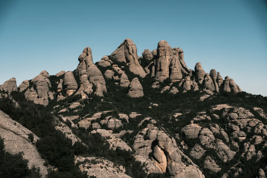 Rounded rock towers rising above wooded mountain slopes.